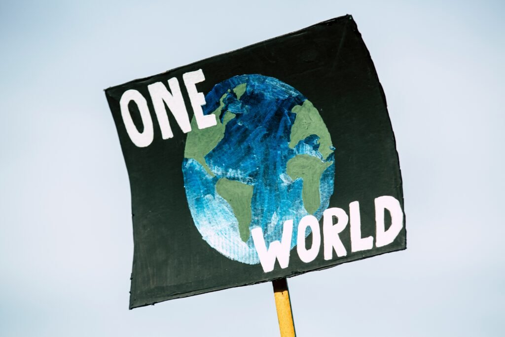 Black sign with earth saying 'one world' 